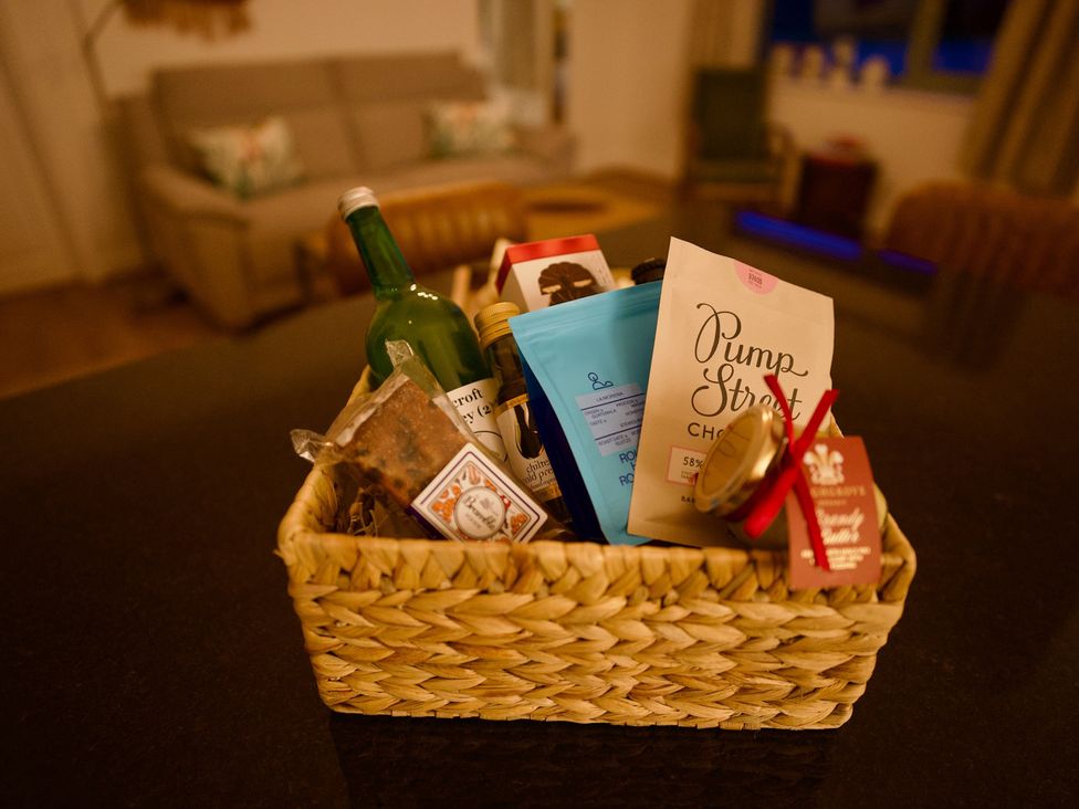 A basket with items including snacks and a bottle in the kitchen at TBC