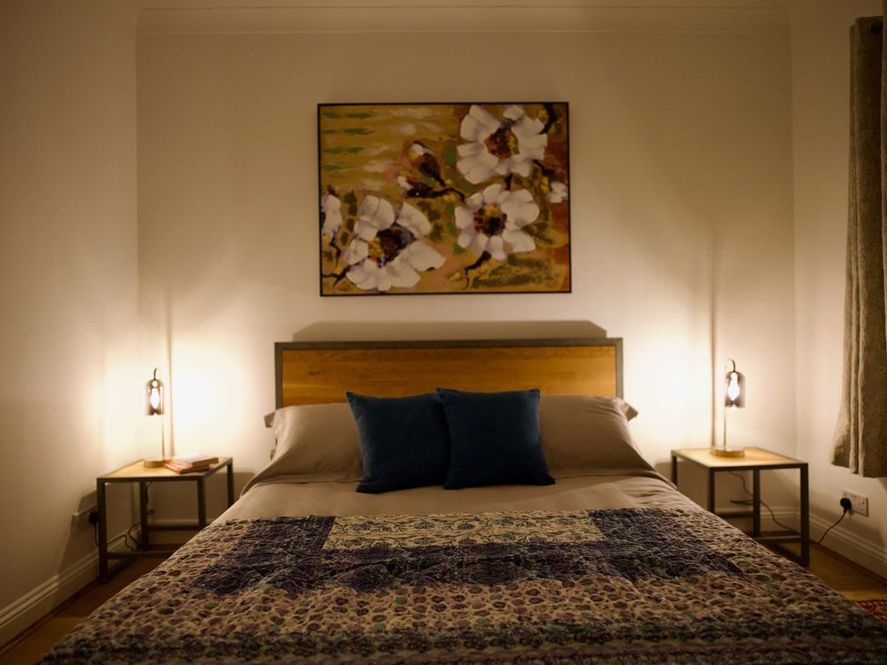 A bedroom with a bed and nightstands at TBC