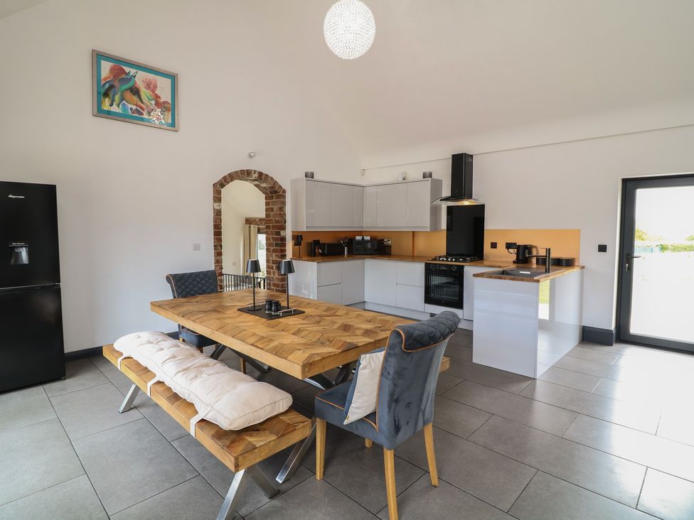 A kitchen with a dining table and chairs at The Croft, Home Farm in Ripley