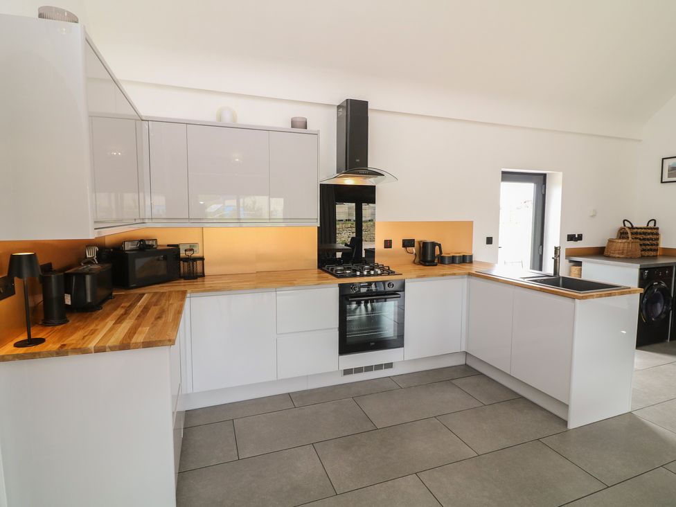 A kitchen with a stove, oven, and cabinets at The Croft, Home Farm in Ripley