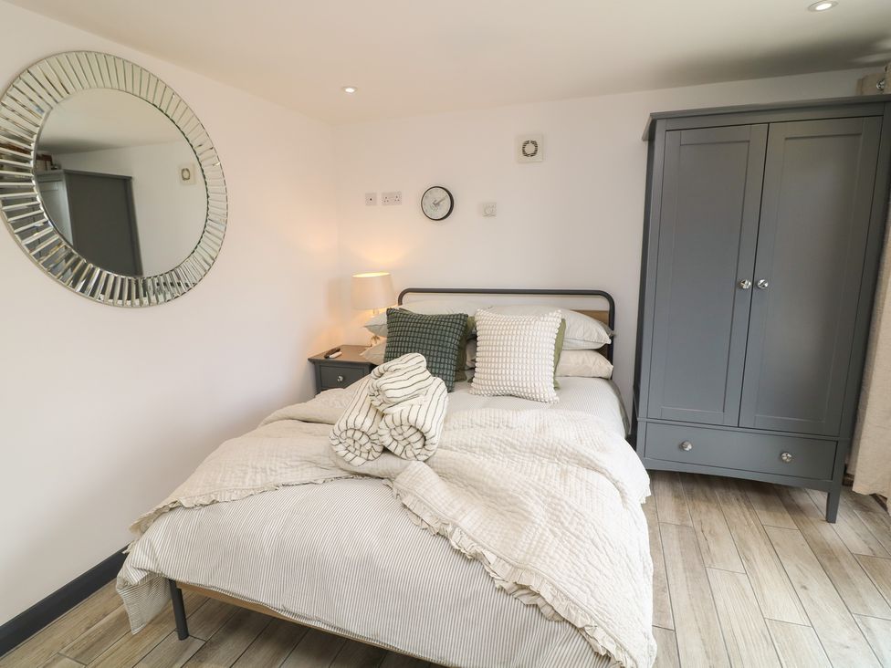 A bedroom with a bed and wardrobe at The Croft, Home Farm in Ripley