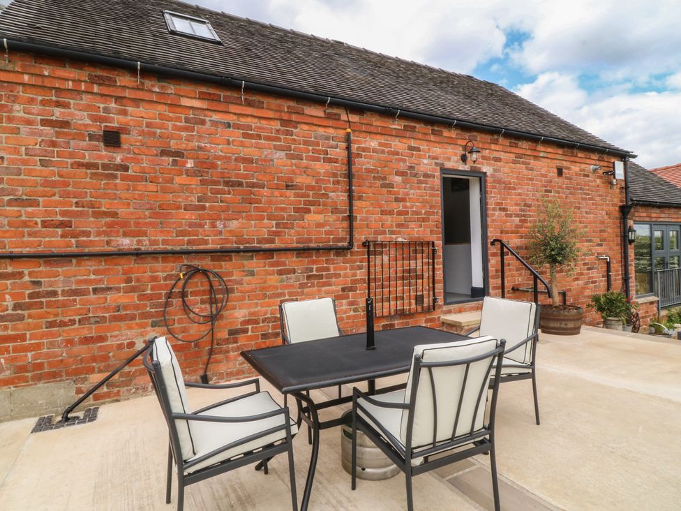 An outdoor patio area with a table and chairs at The Croft, Home Farm Ripley