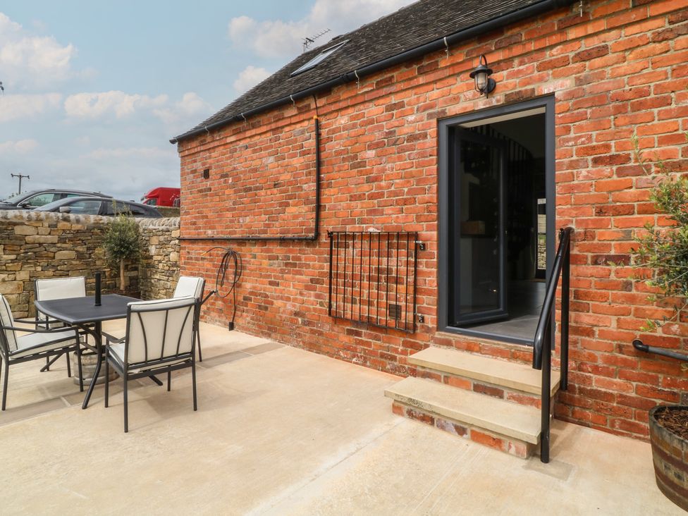 An outdoor seating area with a table and chairs at The Croft, Home Farm in Ripley