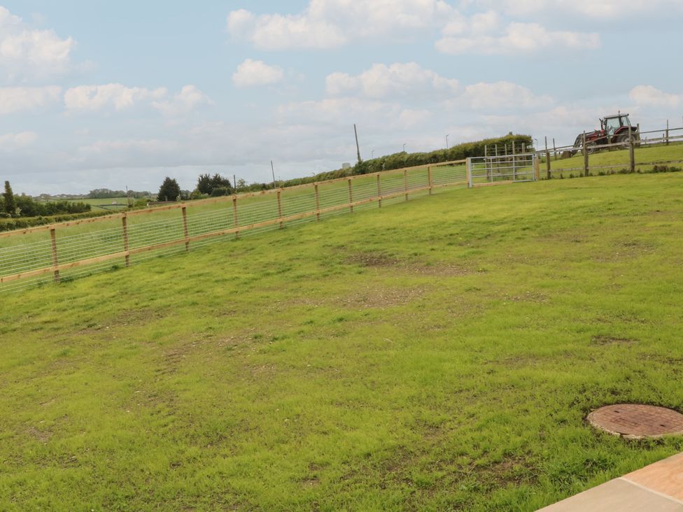An outdoor area with grass and a fence at The Croft, Home Farm Ripley
