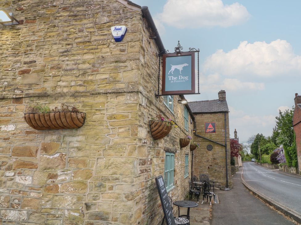 A pub exterior with a sign and outdoor seating at The Dog at Pennich in Ripley