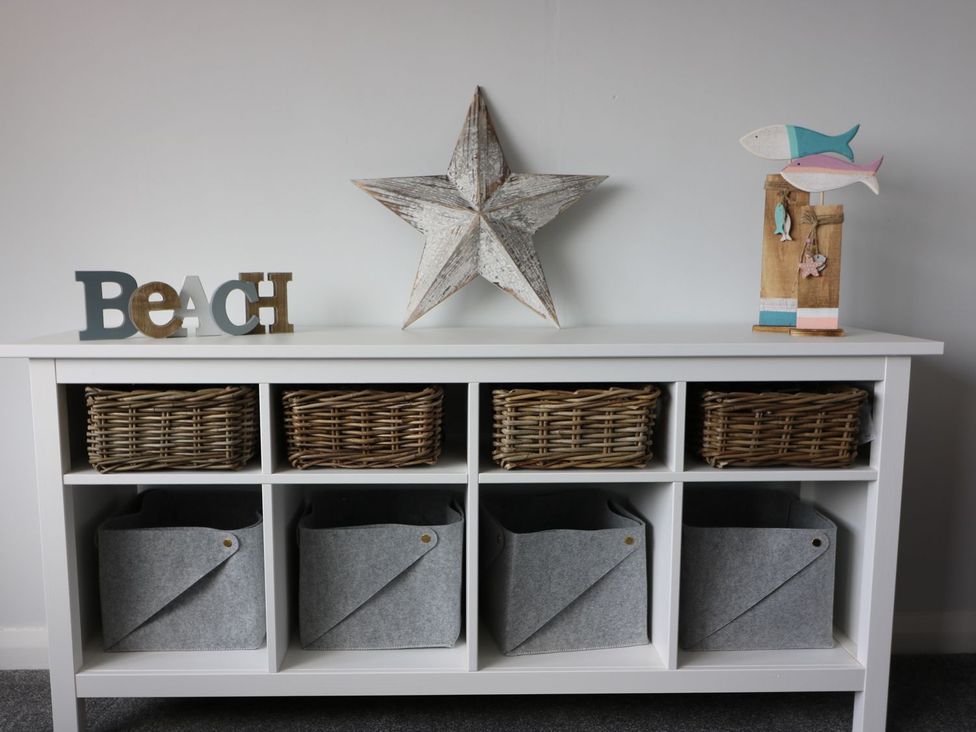 A shelf with woven baskets and decorative items at The Cartwheel in Amroth