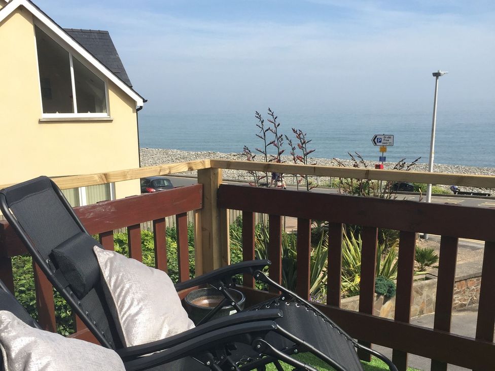 A deck with a chair and sea view at The Cartwheel in Amroth