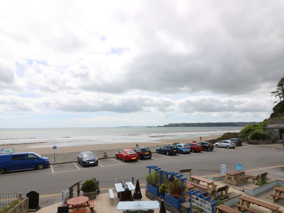 A view of the sea and parking lot with tables at The Cartwheel in Amroth
