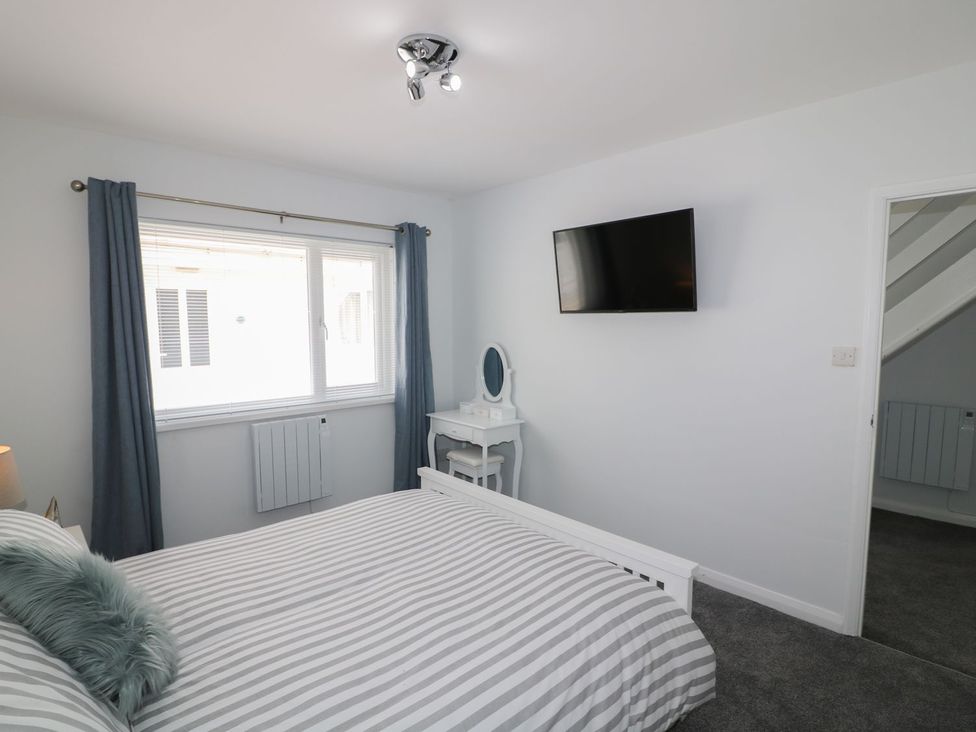A bedroom with a bed and television at The Cartwheel in Amroth