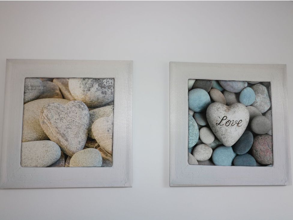 Framed art featuring heart-shaped stones at The Cartwheel in Amroth