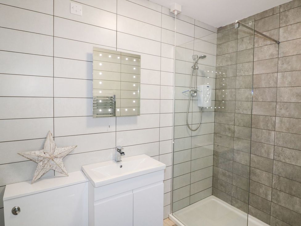 A bathroom with a sink and a shower at The Cartwheel in Amroth
