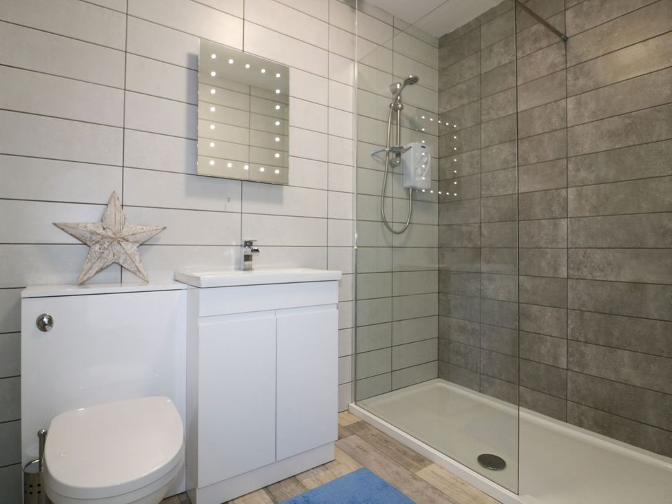 A bathroom with a shower and sink at The Cartwheel in Amroth