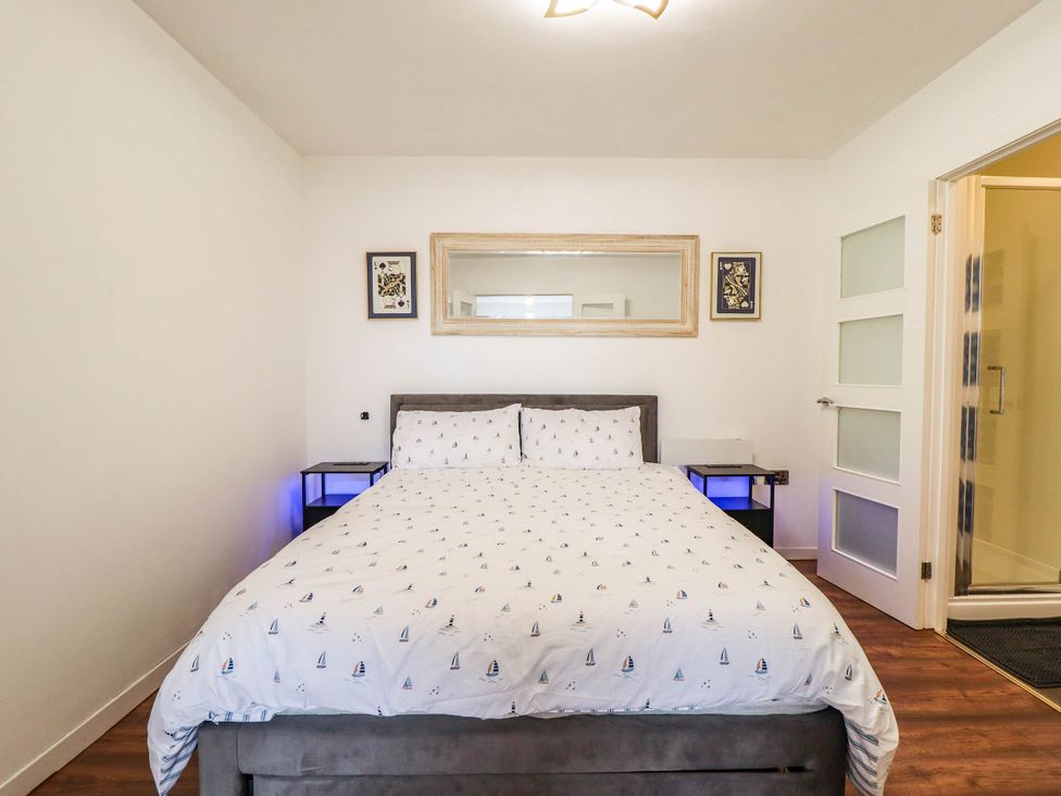 A bedroom with a bed and nightstands at The Ocean House--- Sea Shell in Hunstanton