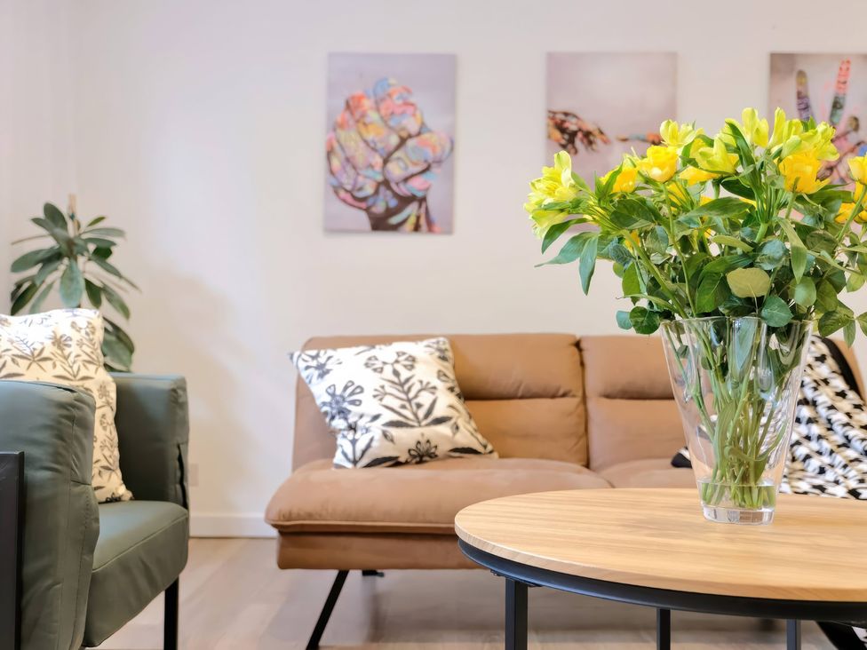 A living room with a sofa, plants and a table at TBC