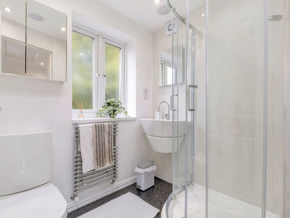 A bathroom with a shower, sink, and toilet at TBC