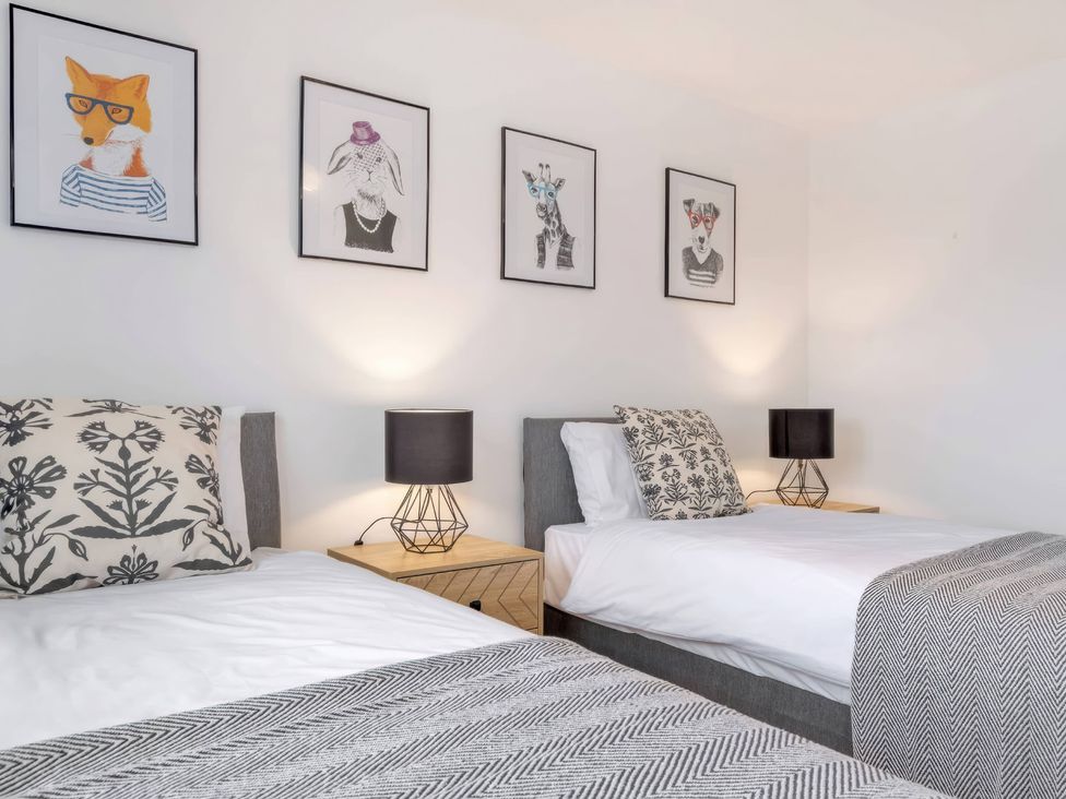 A bedroom with two beds and animal-themed wall art at TBC