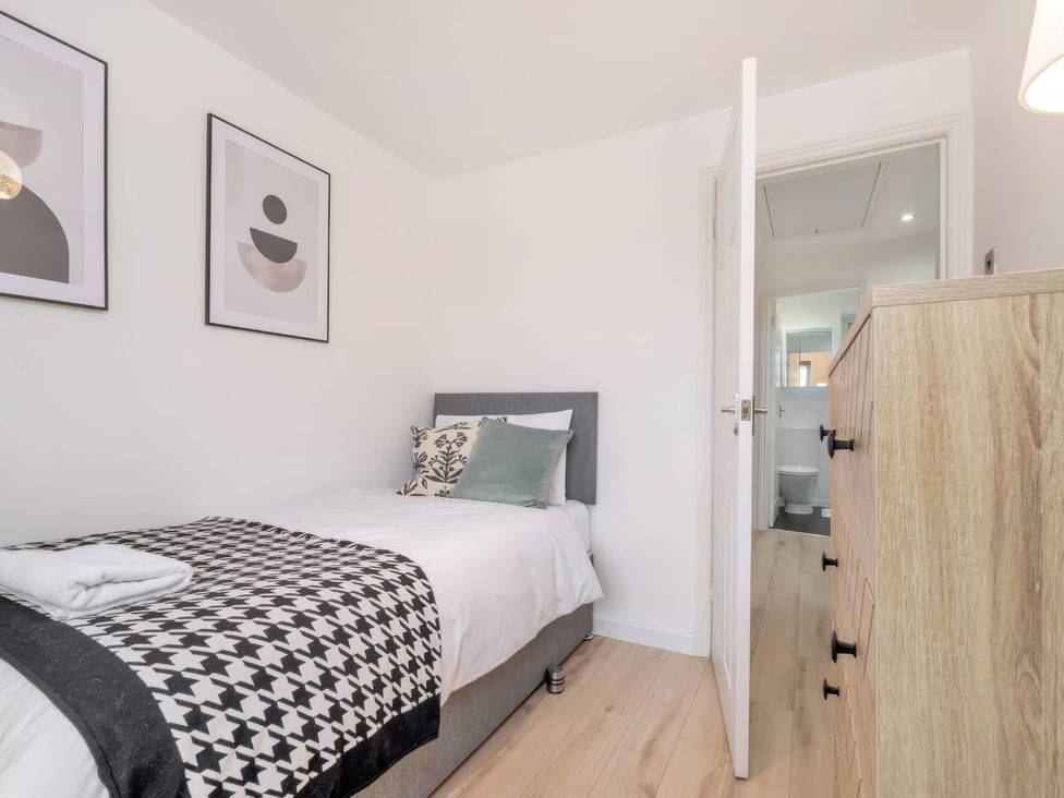 A bedroom with a bed and drawer chest at TBC 