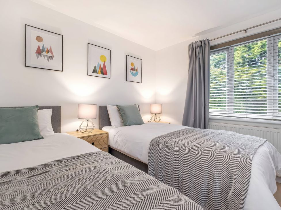 A bedroom with two beds and a window at TBC