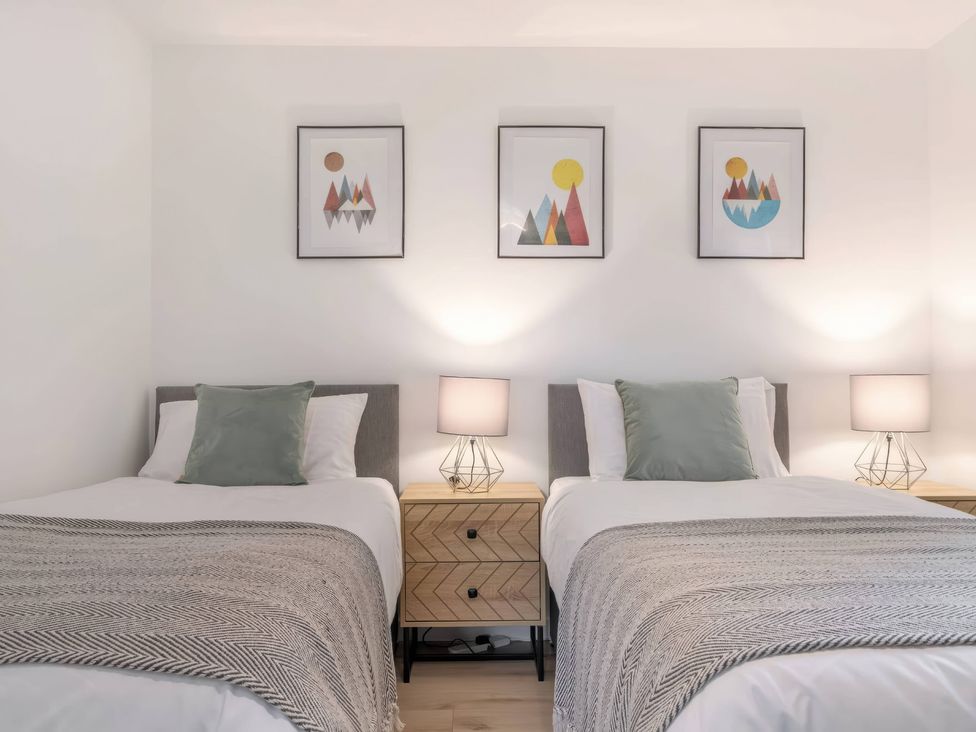 A bedroom with twin beds and artwork on the wall at TBC 