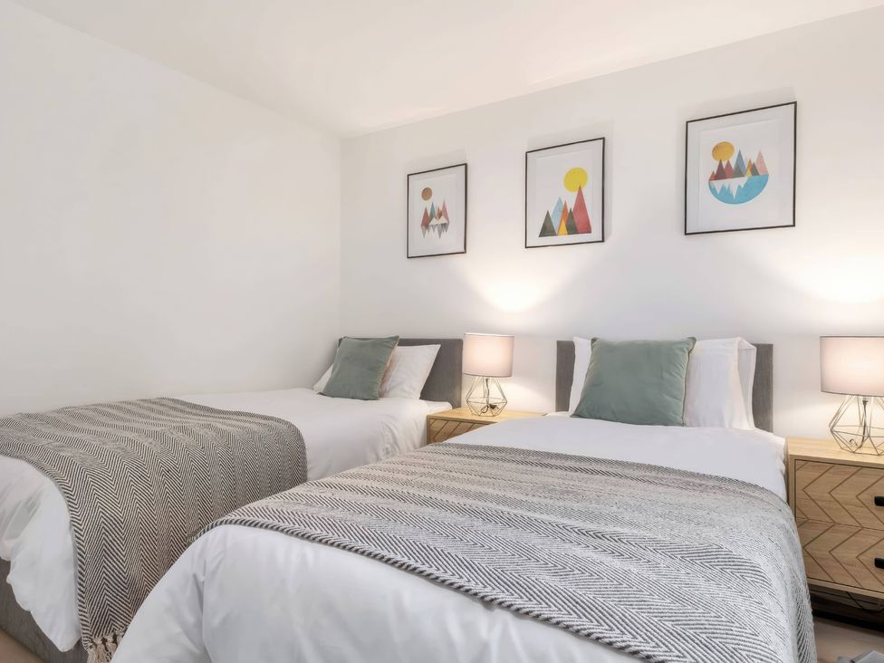 A bedroom with two beds and two lamps at TBC 