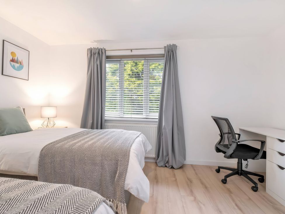 A bedroom with two beds and a desk at TBC in 