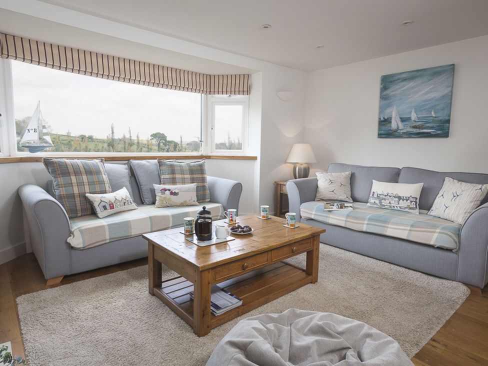 A living room with sofas and a coffee table at 6 Knowle Court in Salcombe