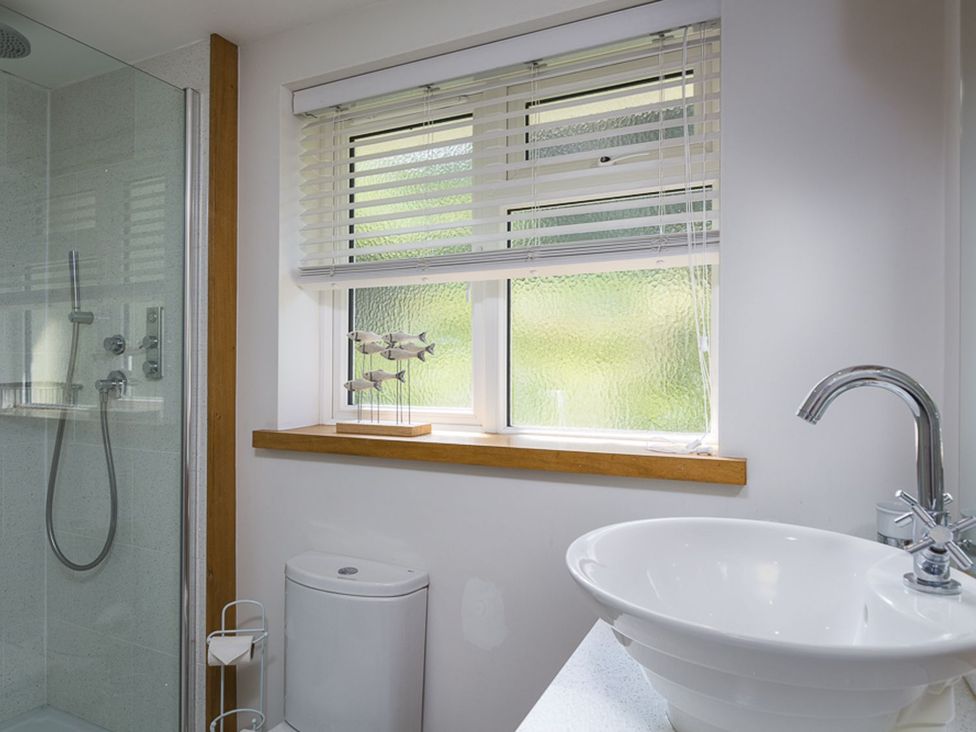 A bathroom with a shower and sink at 6 Knowle Court in Salcombe