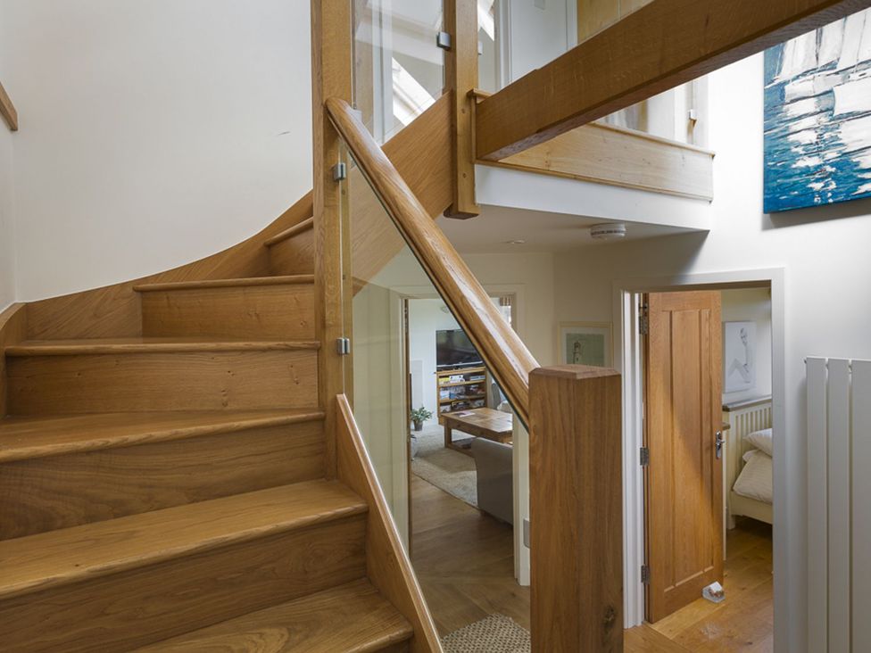 A staircase with wooden steps and railing at 6 Knowle Court Salcombe