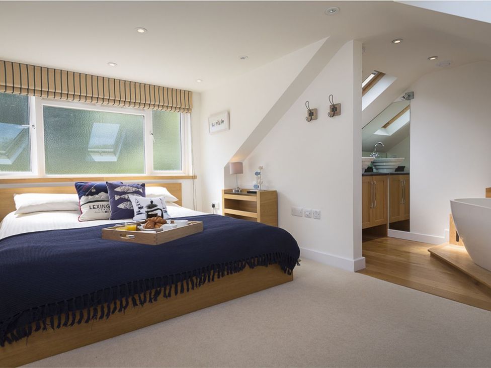A bedroom with a bed and ensuite bathroom at 6 Knowle Court Salcombe