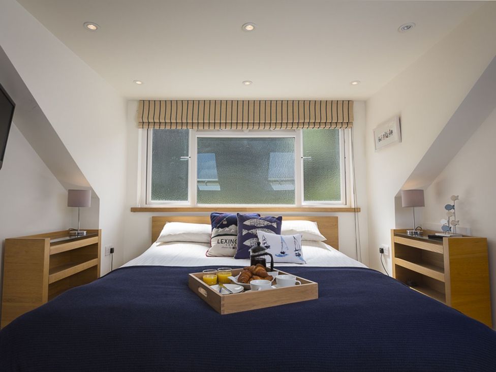 A bedroom with a bed and breakfast tray at 6 Knowle Court in Salcombe