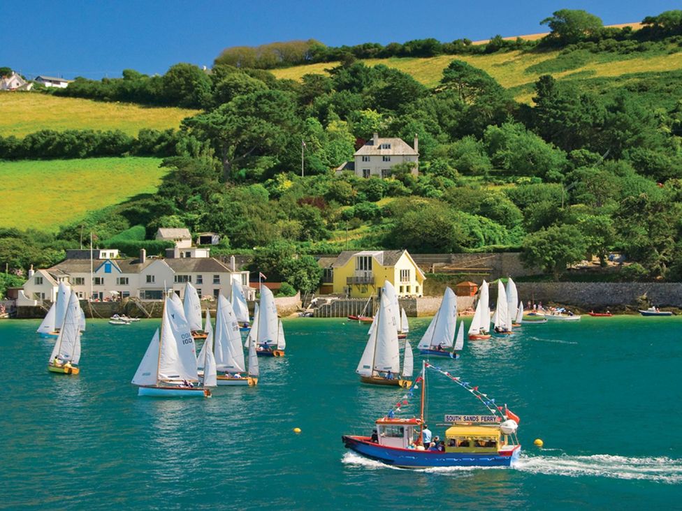 A scene with sailboats and a ferry on water at 6 Knowle Court Salcombe