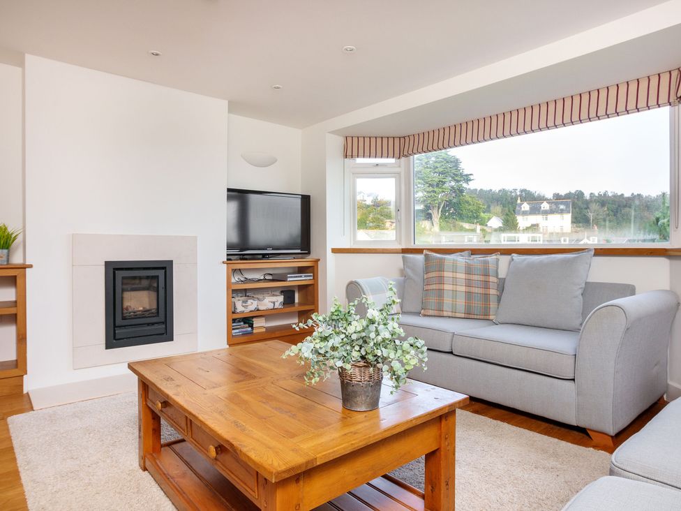A living room with a sofa and coffee table at 6 Knowle Court in Salcombe