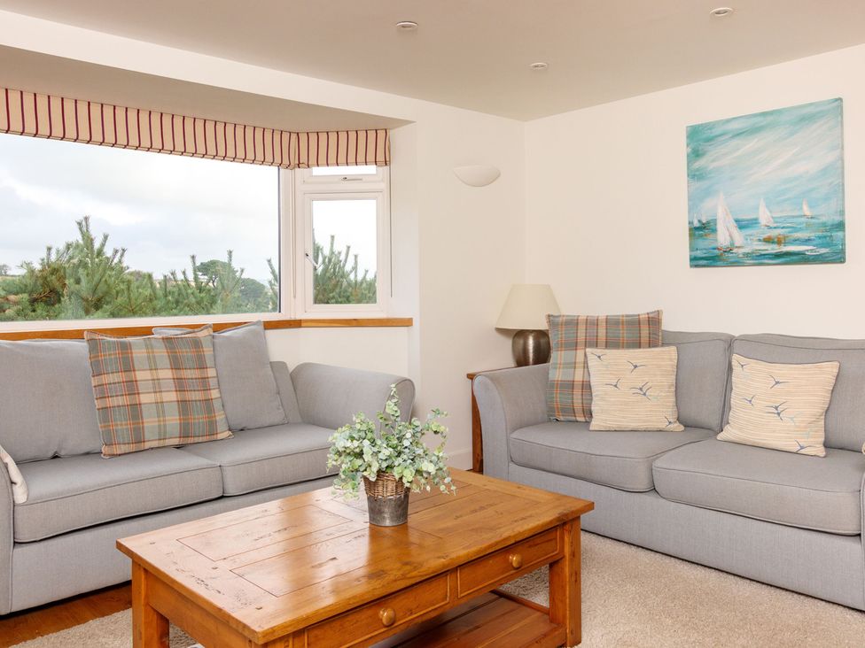 A living room with couches and a table at 6 Knowle Court in Salcombe