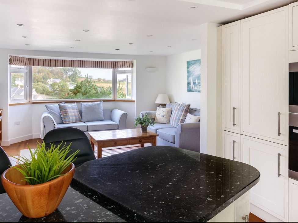 A living room with a sofa and coffee table at 6 Knowle Court in Salcombe