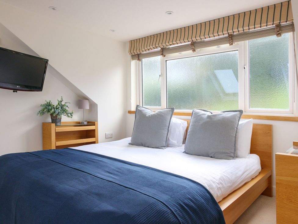 A bedroom with a bed and television at 6 Knowle Court in Salcombe