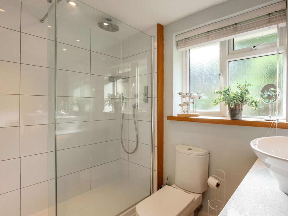 A bathroom with a shower, toilet, and sink at 6 Knowle Court in Salcombe