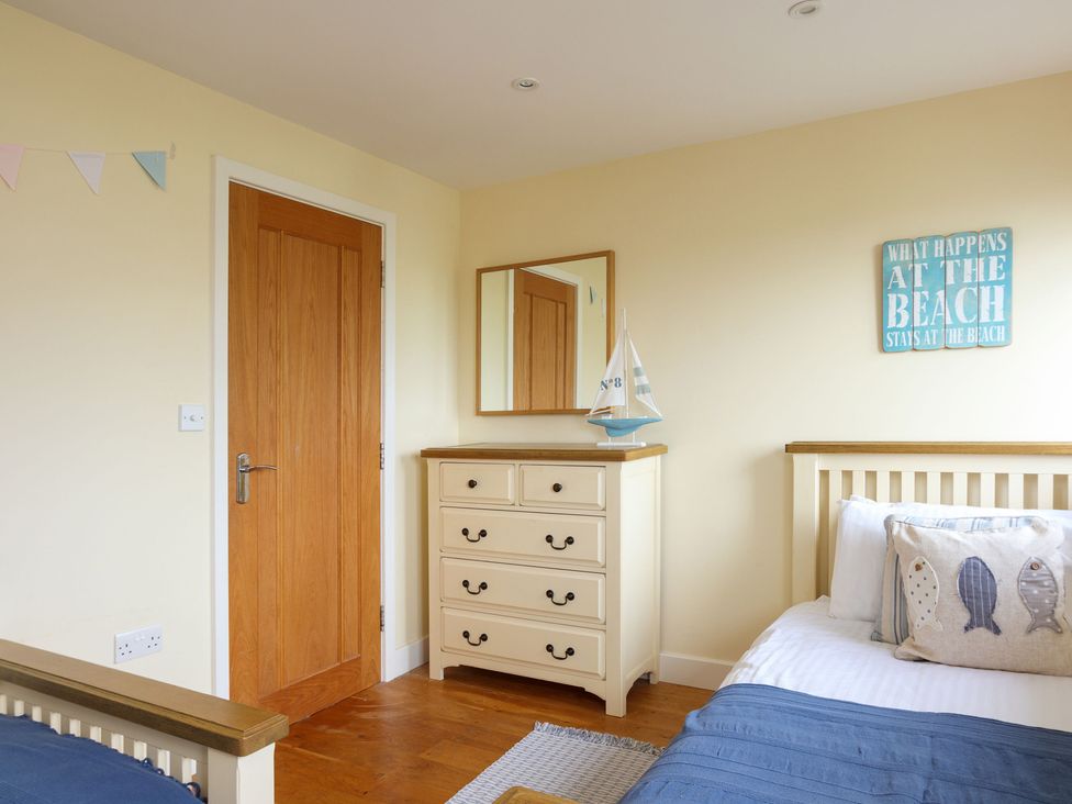 A bedroom with a dresser and single beds at 6 Knowle Court in Salcombe
