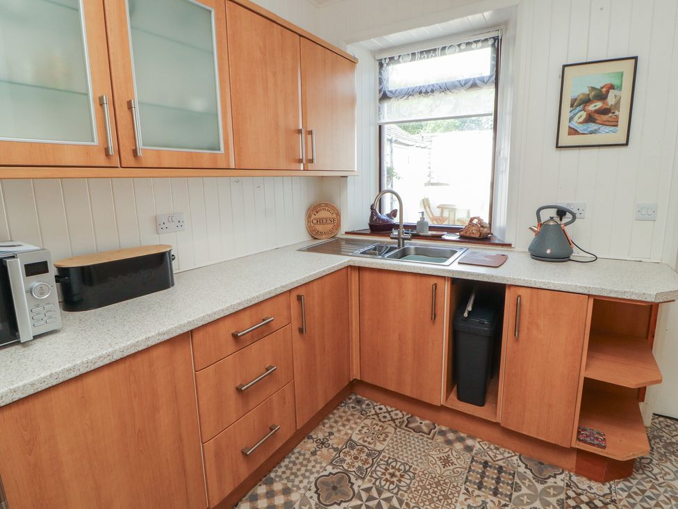 A kitchen with wooden cabinets and a sink at 30 George Street Wigton