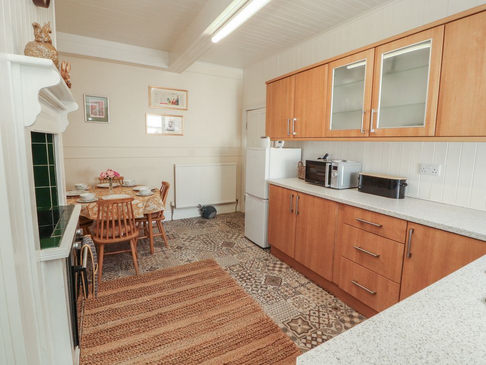 A kitchen with wooden cabinets and appliances at 30 George Street Wigton