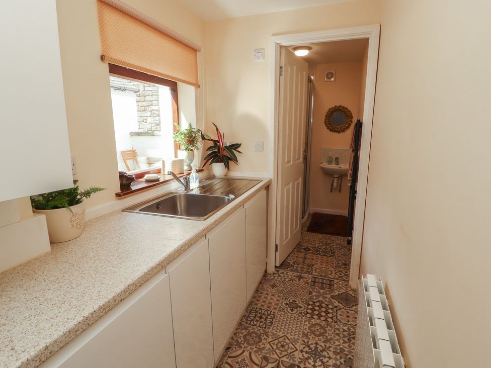 A utility room with a sink and door at 30 George Street, Wigton