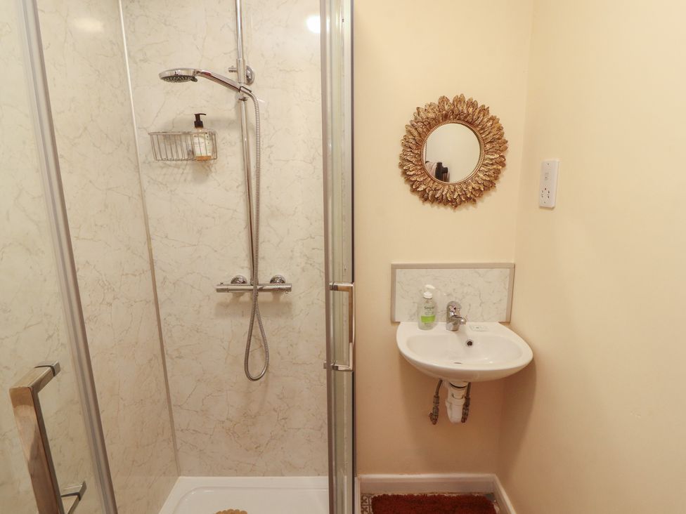 A bathroom with a shower and a small sink at 30 George Street in Wigton