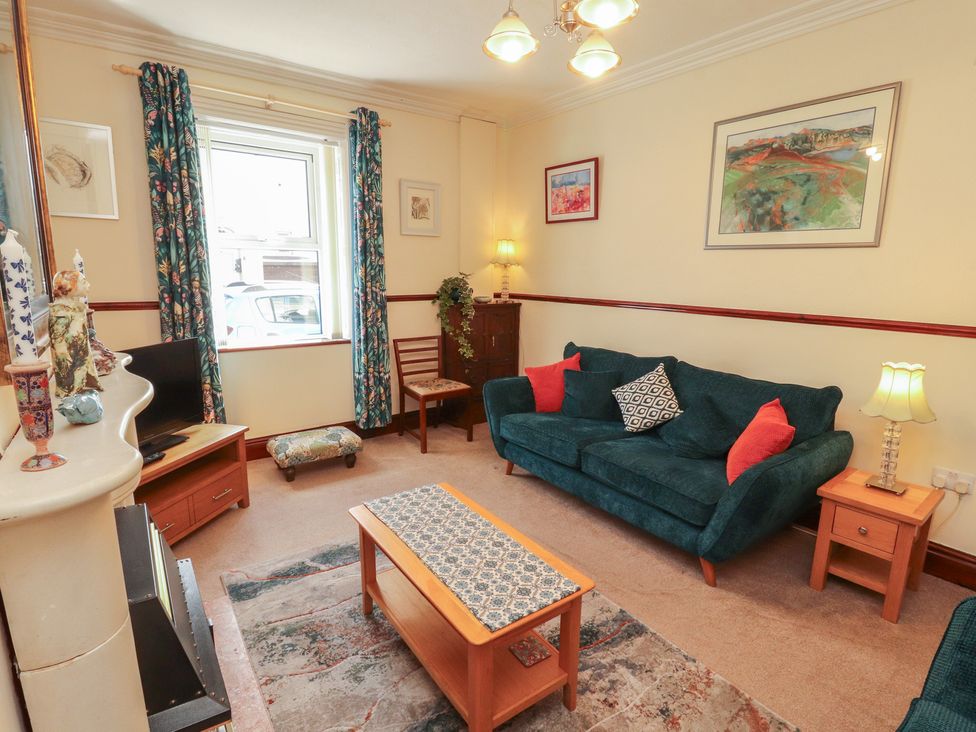 A living room with a sofa, coffee table, and lamp at 30 George Street in Wigton