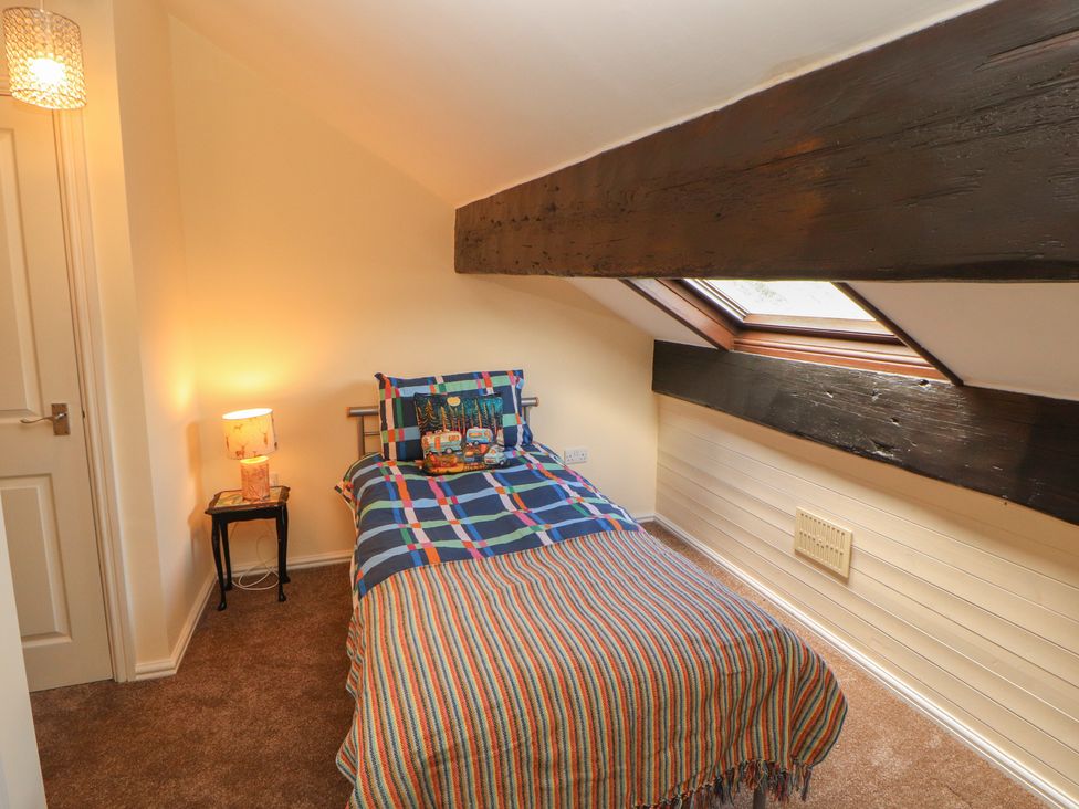 A bedroom with a bed and lamp at 30 George Street in Wigton