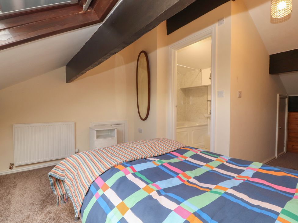 A bedroom with a bed and a mirror at 30 George Street in Wigton