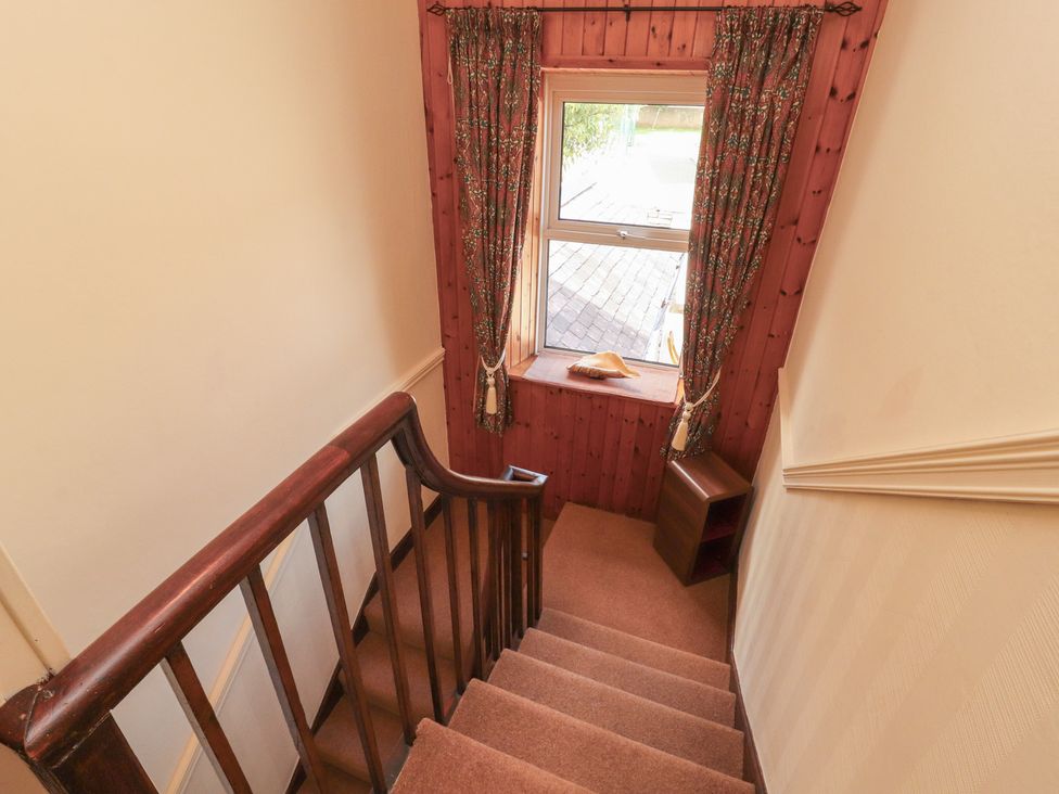 A staircase with a window and small table at 30 George Street in Wigton