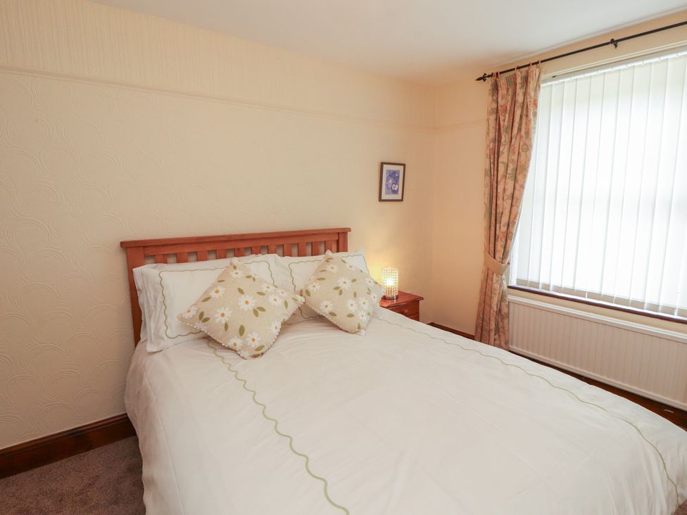 A bedroom with a bed and nightstand at 30 George Street in Wigton