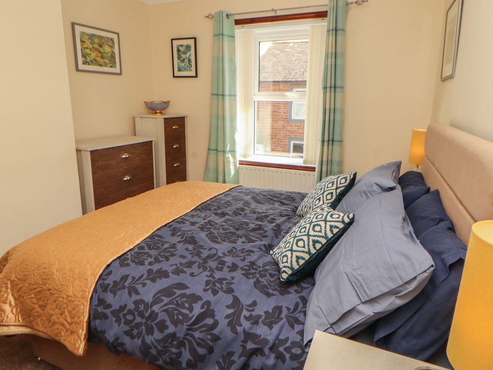 A bedroom with a bed and dresser at 30 George Street in Wigton