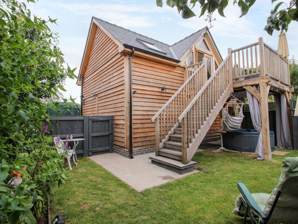 A garden with a wooden house and stairs at Little Acre in Leominster