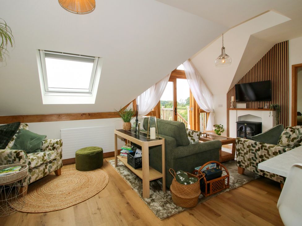 A living room with seating and a television in Little Acre Leominster