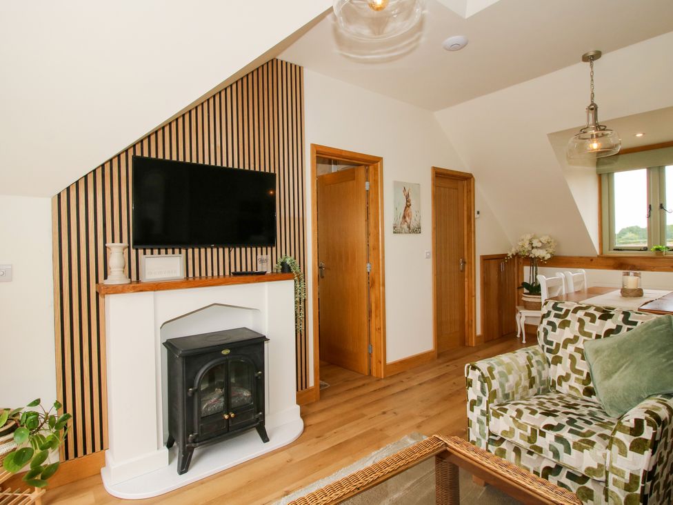 A living room with a television and fireplace at Little Acre in Leominster